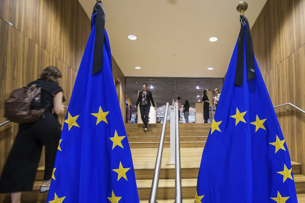 Vista de unas banderas de la Unión Europea con crespones negros colocadas en el recibidor de la sede de la Comisión Europea en Bruselas (Bélgica).