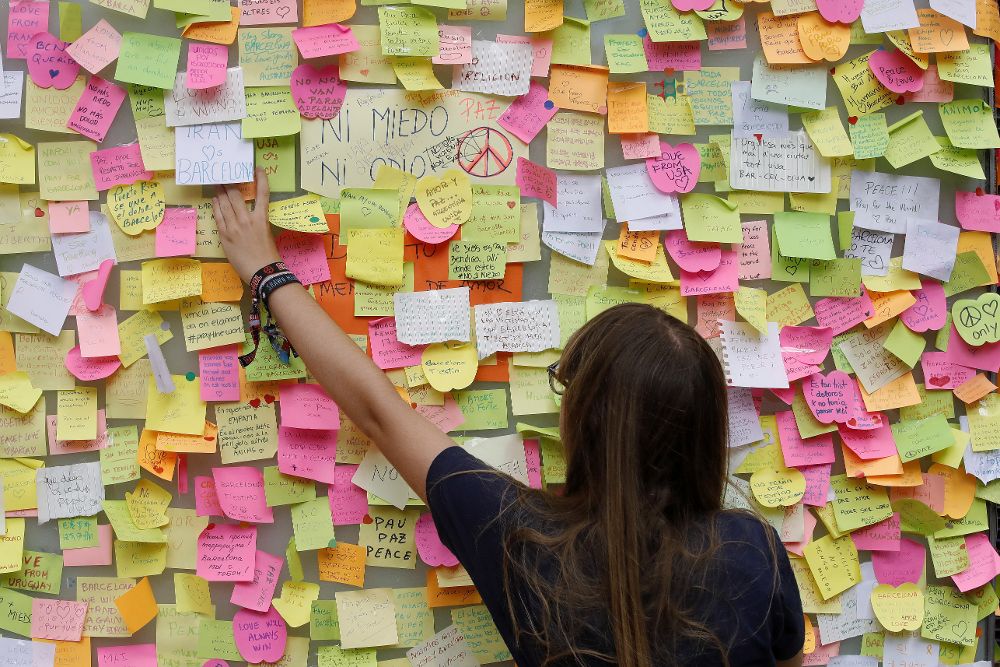 Una mujer deja una nota con un mensaje de apoyo en Las Ramblas de Barcelona, que poco a poco vuelven a la normalidad, dos días después de los atentados.