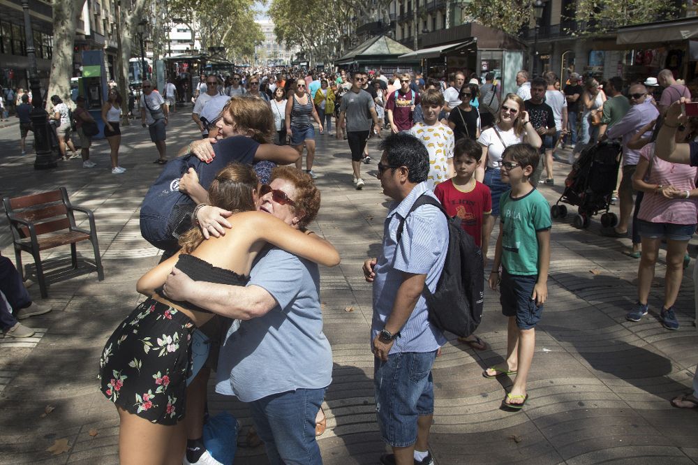 Dos jóvenes dan abrazos "gratis" a todas aquellas personas que se pasean por Las Ramblas de Barcelona.