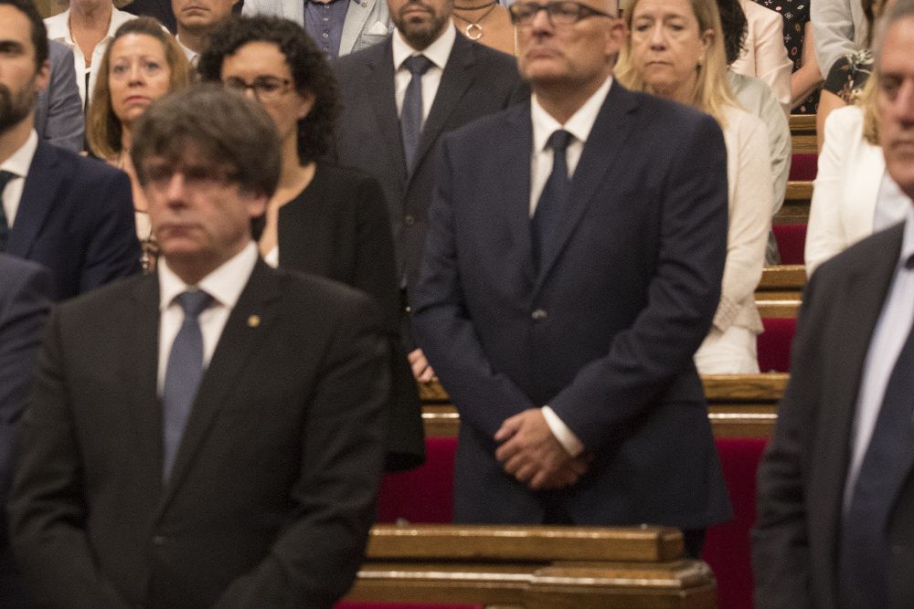 Carles Puigdemont (i) durante el pleno solemne en memoria de las 15 víctimas de los atentados de Barcelona y Cambrils.