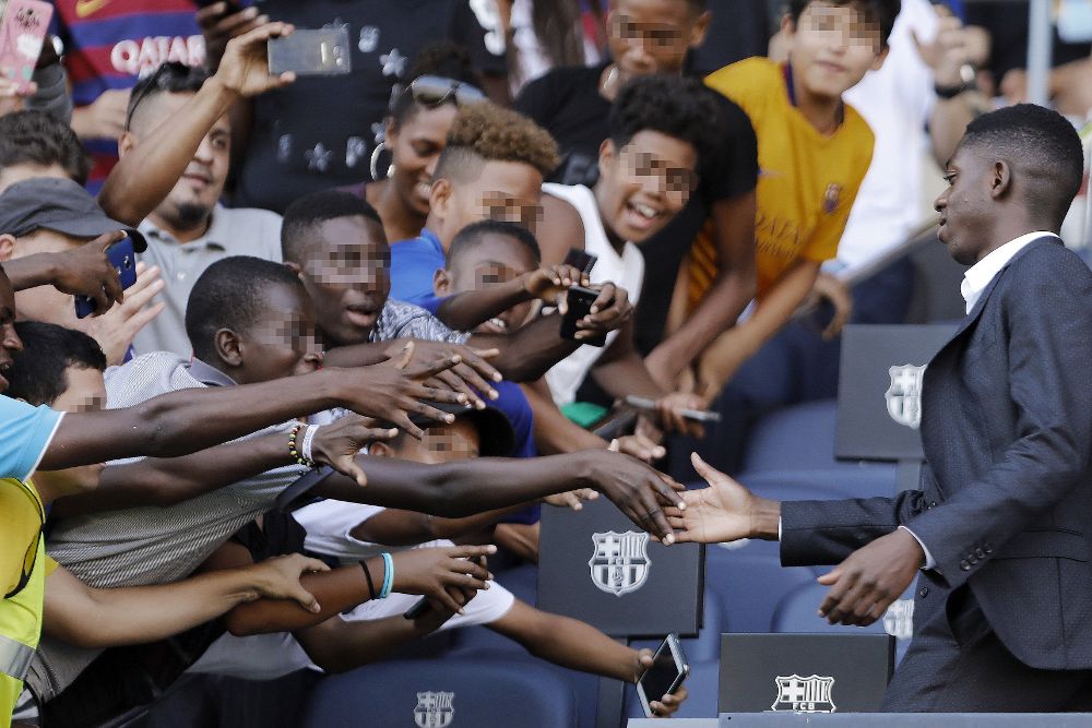 El nuevo fichaje del FC Barcelona, el francés Ousmane Dembélé, saluda a aficionados en el Camp Nou, durante su presentación como nuevo jugador del equipo azulgrana.