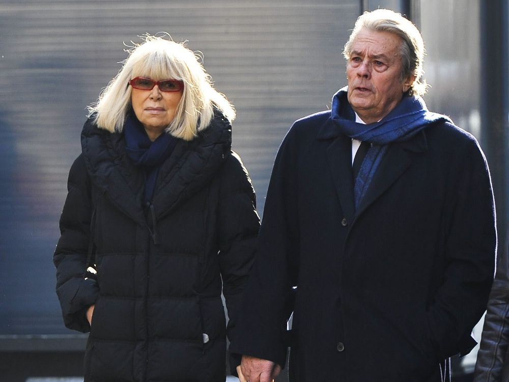 Foto de archivo de los actores galos Mireille Darc (izq) y Alain Delon a su llegada a la iglesia de Saint Roch para asistir al funeral de la actriz francesa Annie Girardot, en París (Francia) el 4 de marzo de 2011.