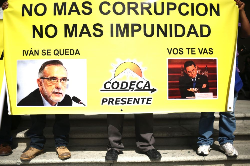 Vista de un cartel en apoyo al titular, el abogado colombiano Iván Velásquez (i), y en rechazo al presidente guatemalteco, Jimmy Morales (d).