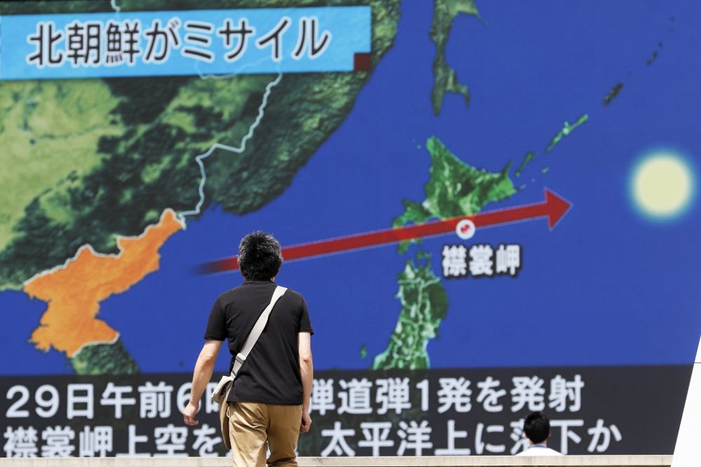 Un viandante observa la trayectoria del misil norcoreano en una pantalla gigante colocada en Tokio (Japón) hoy, 29 de agosto de 2017. 