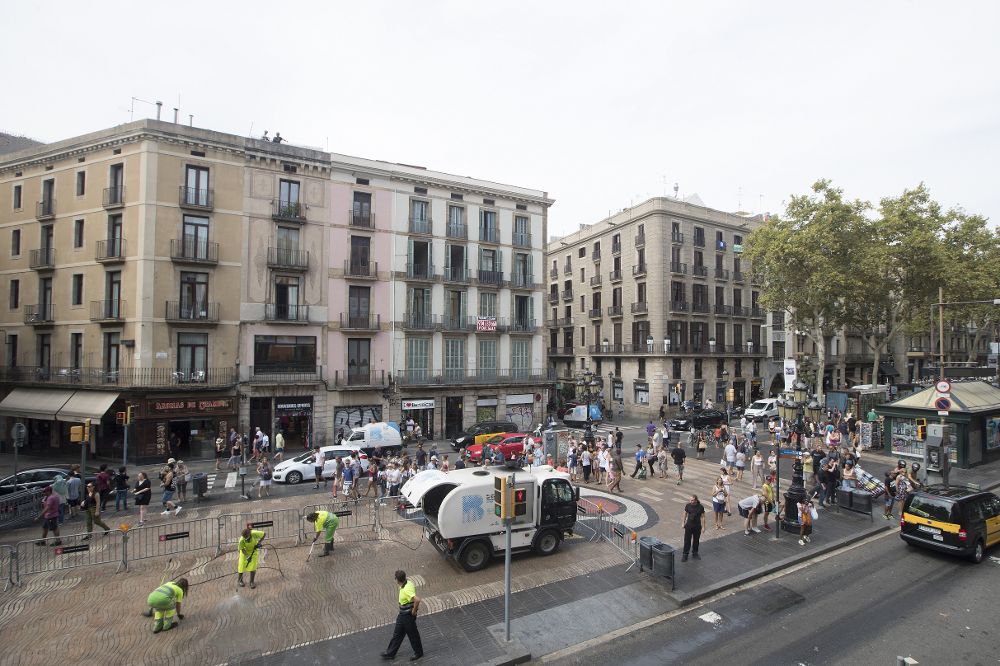 Operarios de limpieza quitando de las Ramblas de Barcelona las últimas ofrendas en memoria de las víctimas de los atentados ocurridos el pasado día 17.