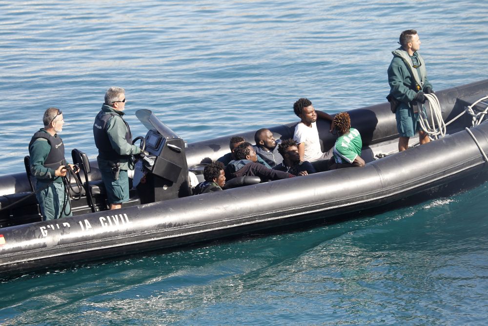 Efectivos de la Guardia Civil a bordo de una zódiac se disponen a desembarcar en el puerto de Tarifa (Cádiz) a algunas de las 26 personas de origen subsahariano rescatadas por Salvamento Marítimo en aguas del estrecho en tres embarcaciones de juguete.