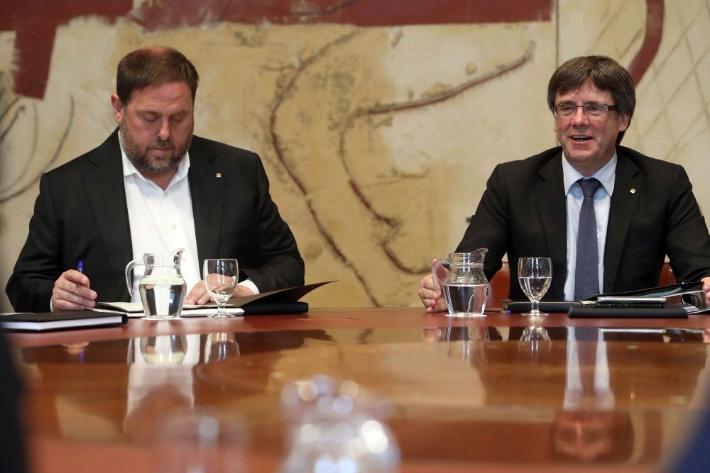 El presidente de la Generalitat, Carles Puigdemont (c), junto al vicepresidente, Oriol Junqueras.