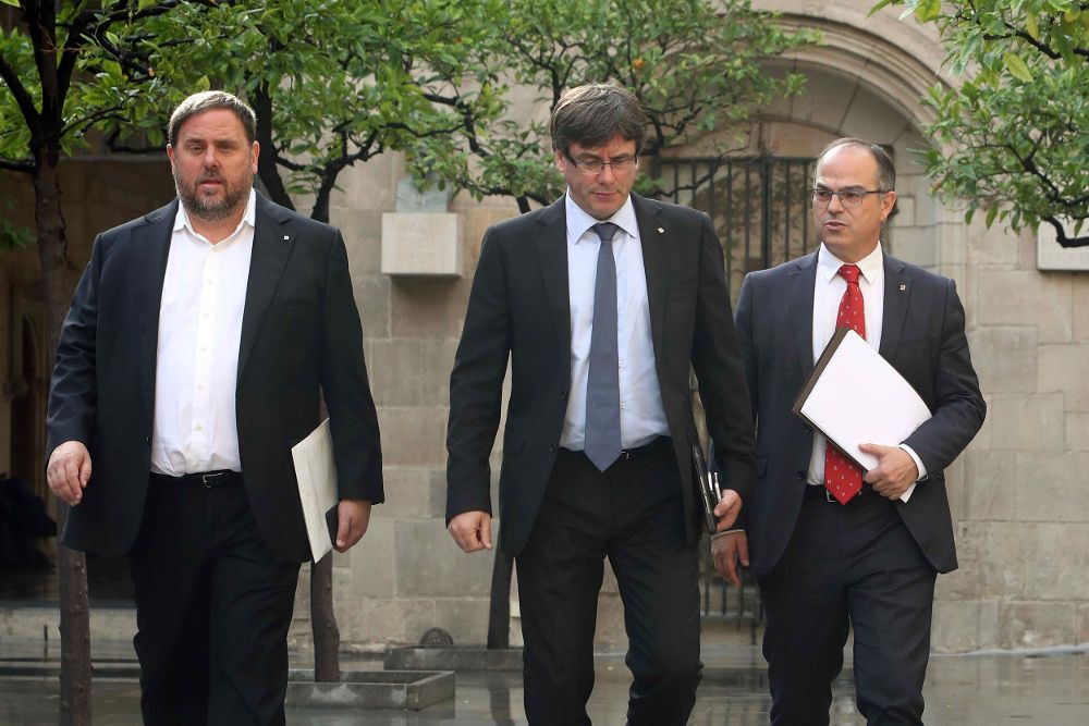 El presidente de la Generalitat, Carles Puigdemont (c), junto al vicepresidente, Oriol Junqueras (i), y el conseller de Presidencia, Jordi Turull (d).