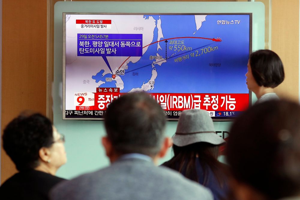 Ciudadanos surcoreanos miran una cadena de televisión que informa de misiles balísticos de Corea del Norte.