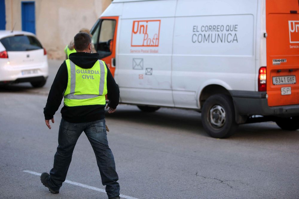 Un guardia civil ante las instalaciones de la empresa de mensajería privada Unipost en L'Hospitalet de Llobregat (Barcelona).