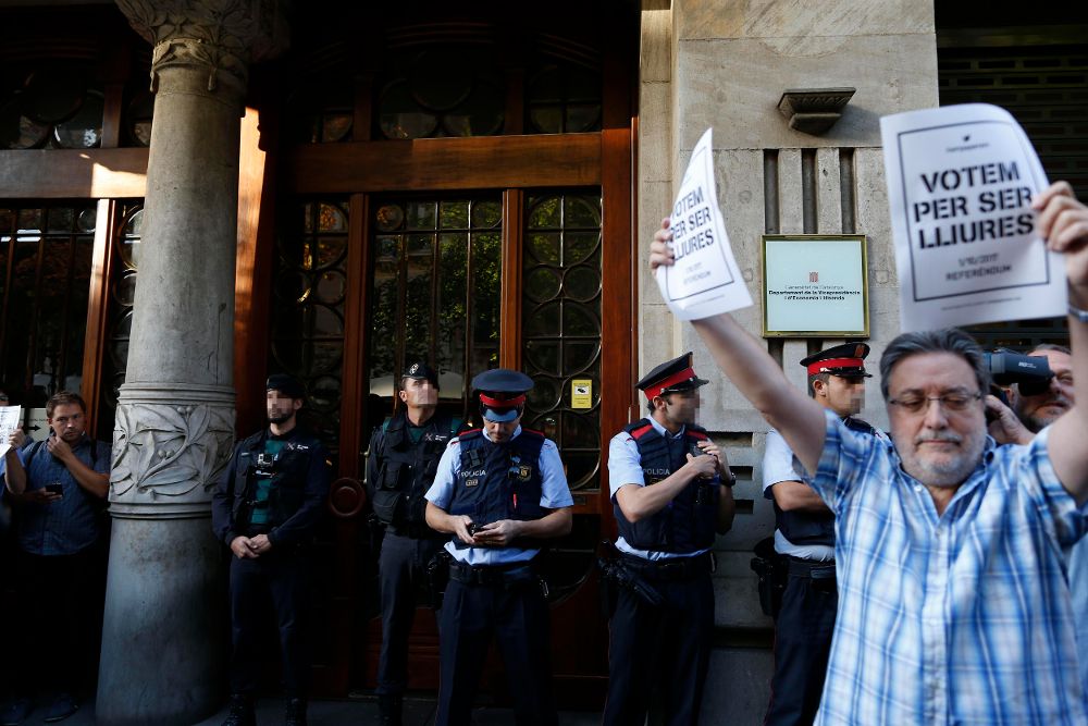 Agentes de la Guardia Civil y de los Mossos d'Esquadra, en la puerta de la consellería de Economía de la Generalitat.