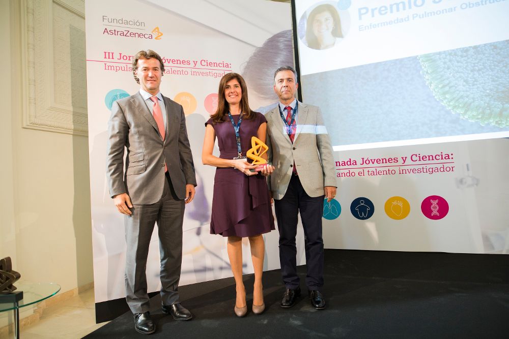 Elizabeth Córdoba, en el momento de recibir su premio de manos de dos representantes de la Fundación AstraZeneca.