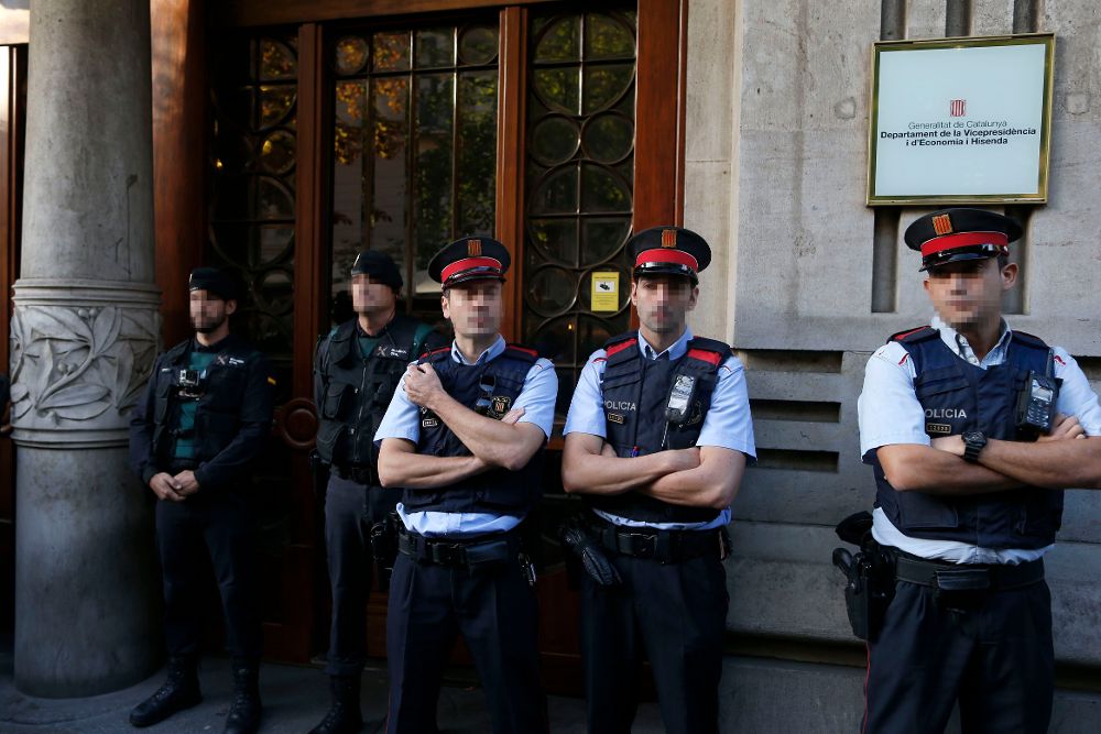 Agentes de la Guardia Civil y de los Mossos d'Esquadra en la puerta de la consellería de Economía de la Generalitat, esta mañana. 