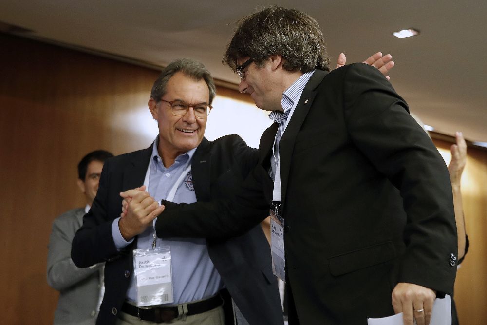 El presidente de la Generalitat, Carles Puigdemont, recibe el saludo del expresidente Artur Mas.