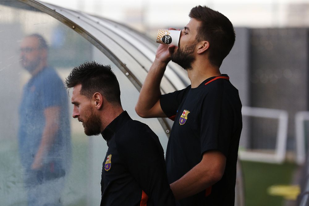 Gerard Piqué (d) con su compañero en el Barça Lionel Messi, durante el entrenamiento en la ciudad deportiva Joan Gamper.