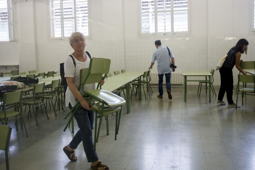 La consellera de Educación, Clara Ponsatí, ayuda a colocar sillas en el colegio Concepció, situado en la calle Bruc de Barcelona.