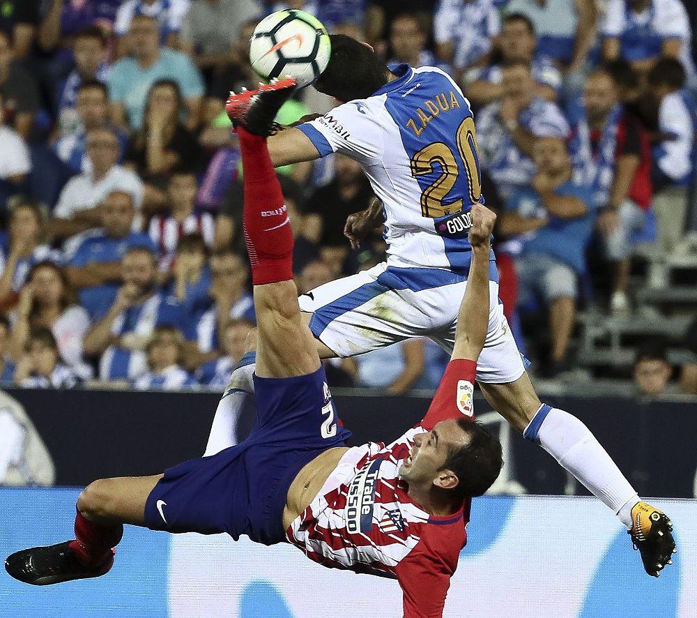 Diego Godín (abajo) lucha el balón con el jugador del Leganés, Joseba Zaldúa.