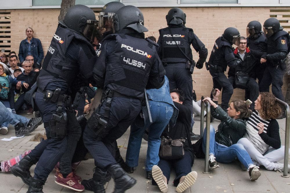 La Policía Nacional forcejea con unos ciudadanos. Las sedes de los centros de votación del 1-O en la ciudad de Lleida están viviendo una mañana protagonizada por la incertidumbre, las actuaciones policiales y los votos telemáticos.