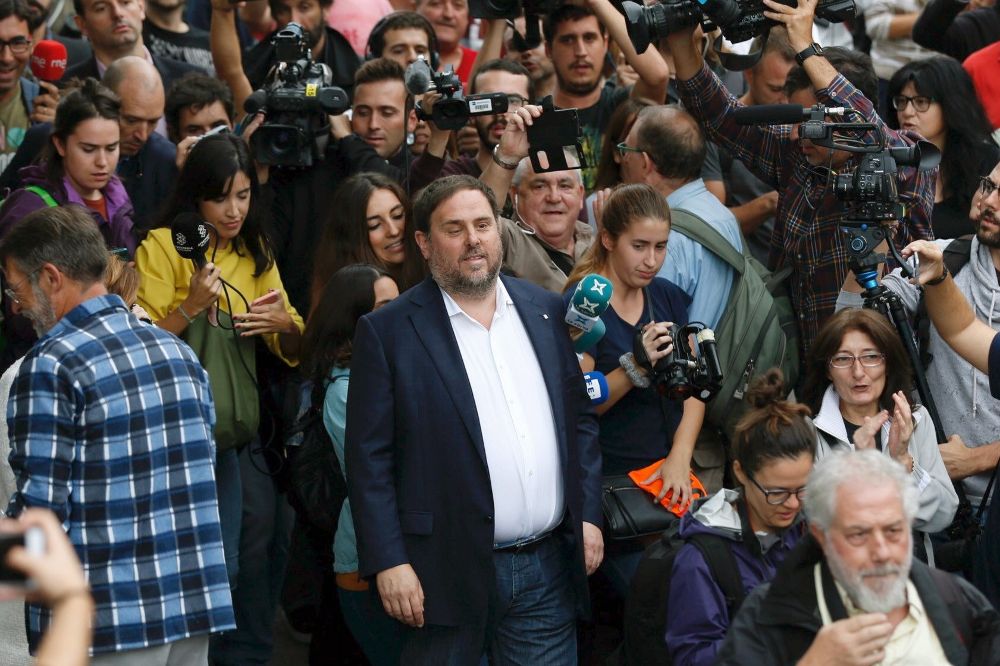 El vicepresidente de la Generalitat, Oriol Junqueras, saluda a un mosso a su llegada Escuela Sant Jordi de Barcelona para votar.