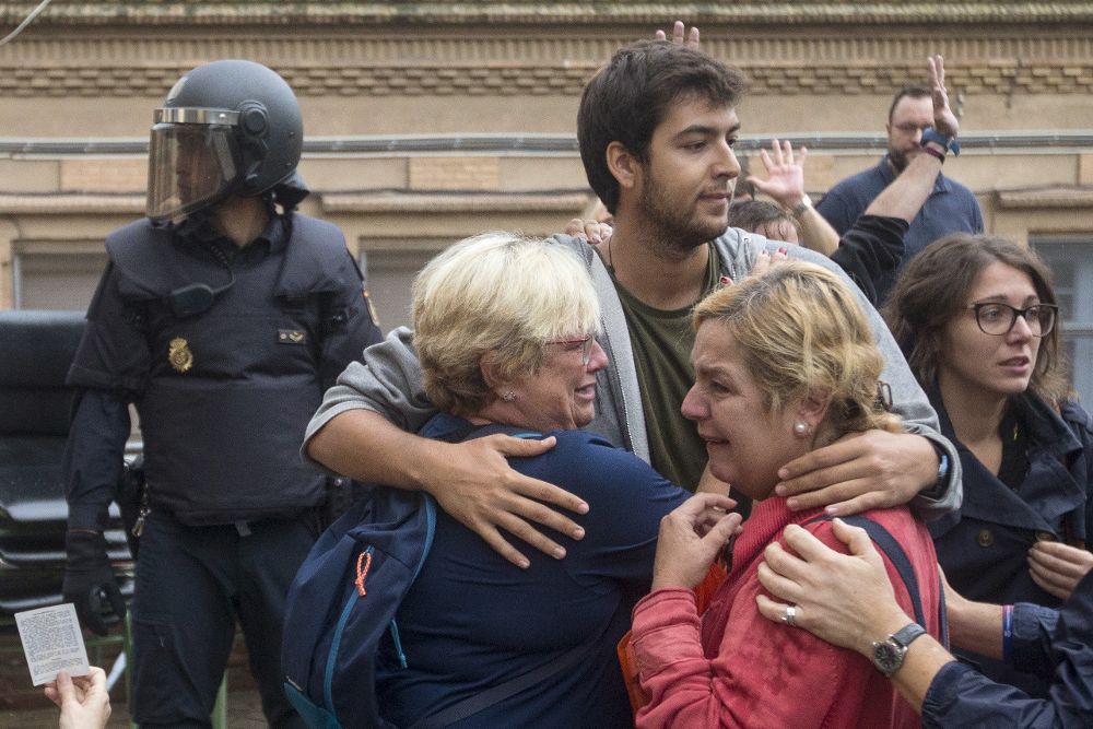 Varias personas lloran en el exterior del Instituto Can Vilumara de L'Hospitalet de Llobregat. 