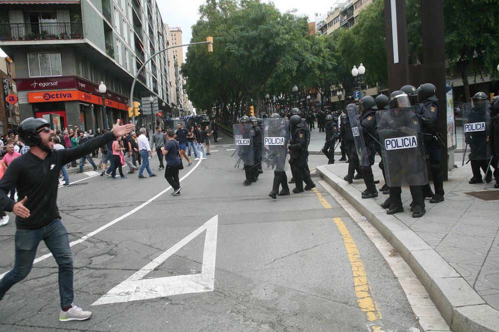 Agentes de la policía nacional forman un cordón policial en el exterior del IES Tarragona. 