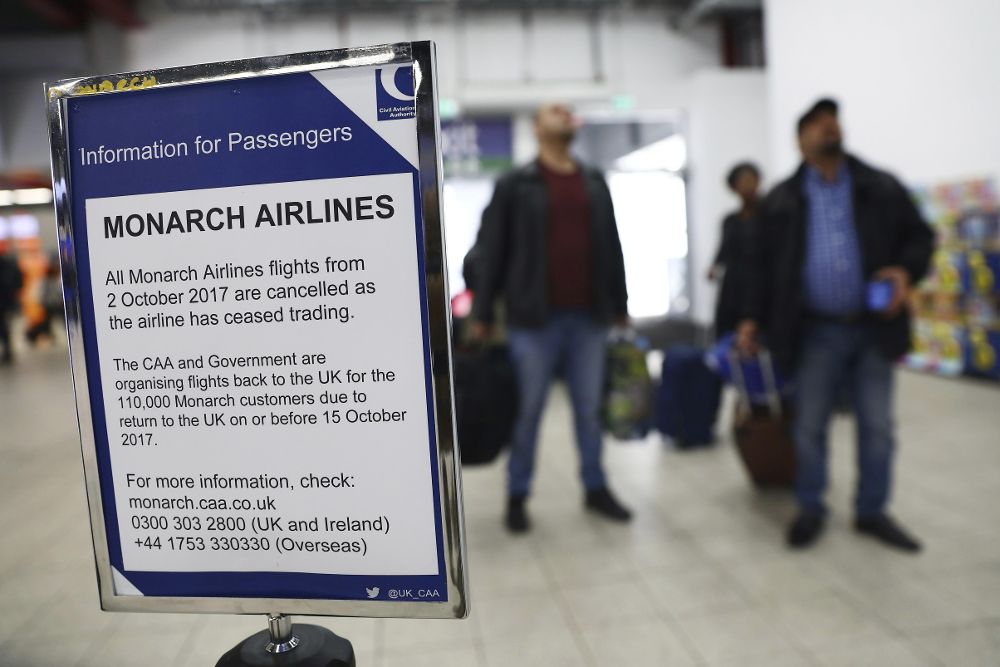 Un cartel informa a los pasajeros del cese de operaciones de la aerolínea Monarch Airlines, en el aeropuerto de Luton, Reino Unido.