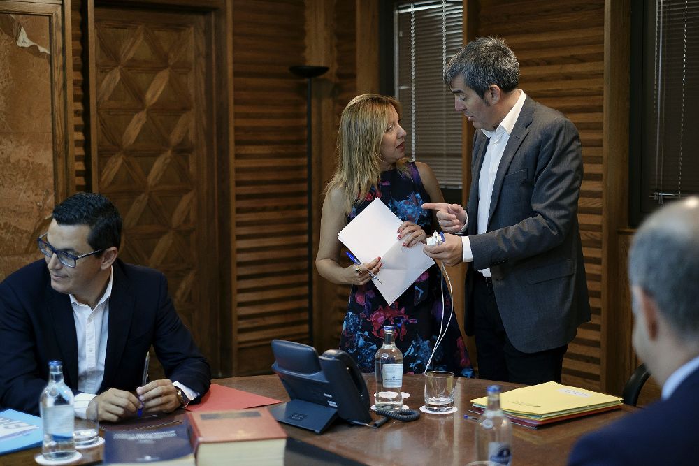 El presidente del ejecutivo regional, Fernando Clavijo (d) habla con la consejera de Hacienda, Rosa Dávila, al inicio de la reunión del Consejo de Gobierno, celebrada hoy en Las Palmas de Gran Canaria.