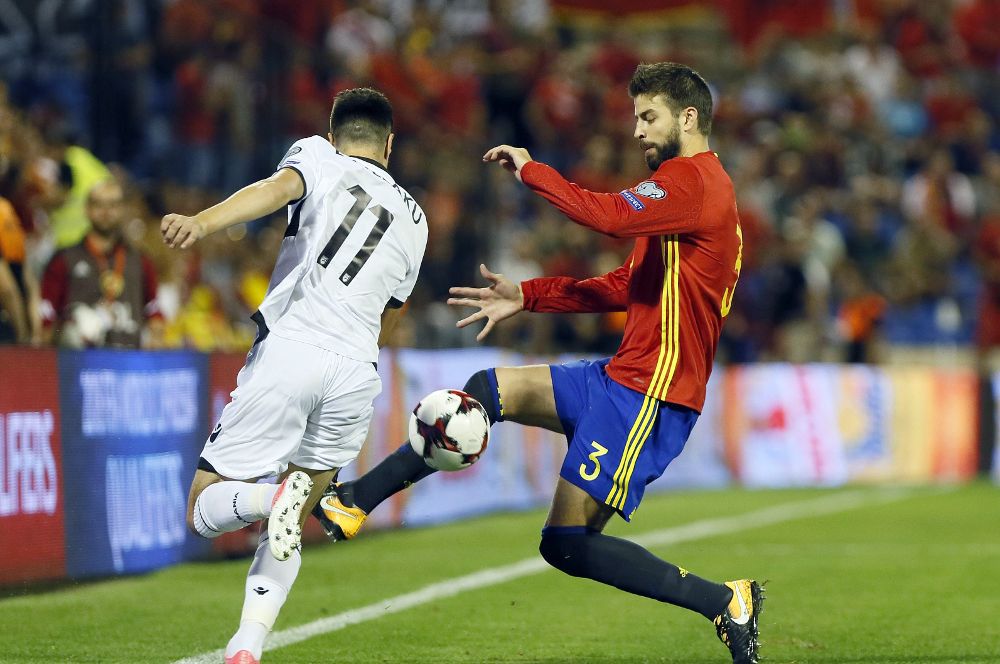 El defensa de España Gerard Piqué (d) pelea un balón con el delantero de Albania Azdren Llullaku.