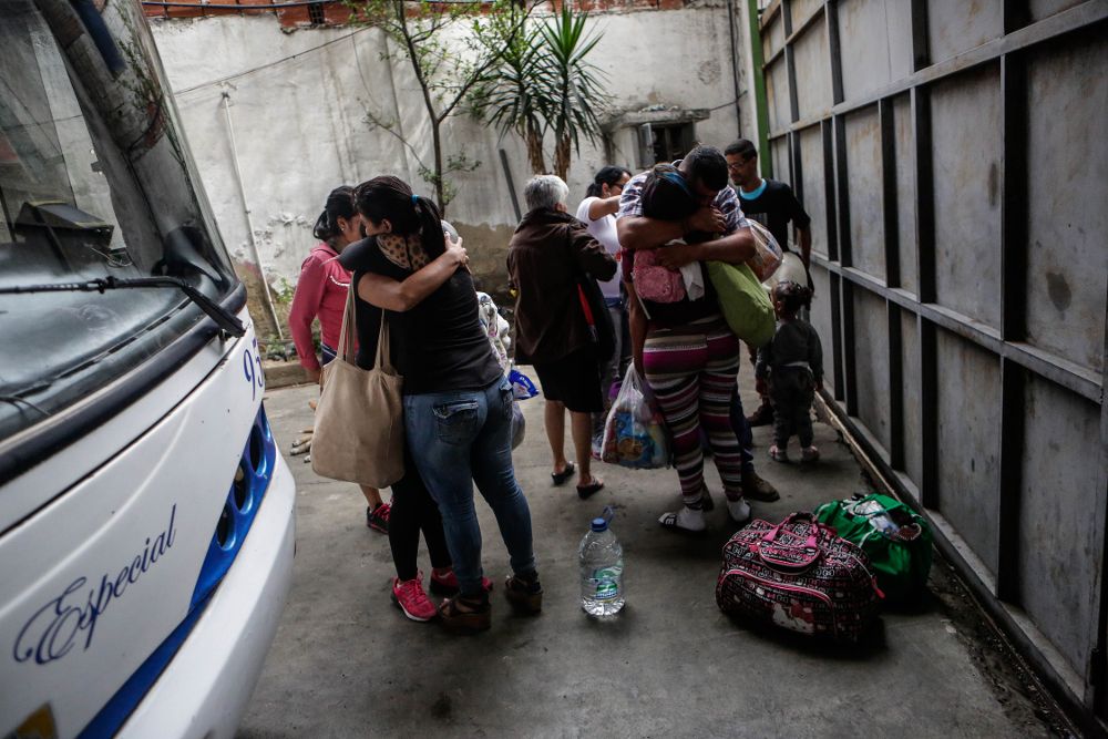 Fotografía del 29 de septiembre de 2017, que muestra a familias que se despiden antes de abordar uno de los autobuses en Caracas (Venezuela) con destino a diferentes países suramericanos.