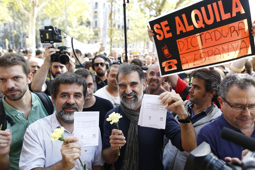 El presidente de la Asamblea Nacional Catalana (ANC), Jordi Sanchez (i), y el presidente de Òmnium Cultural, Jordi Cuixart (c), muestran papeletas del referendum.