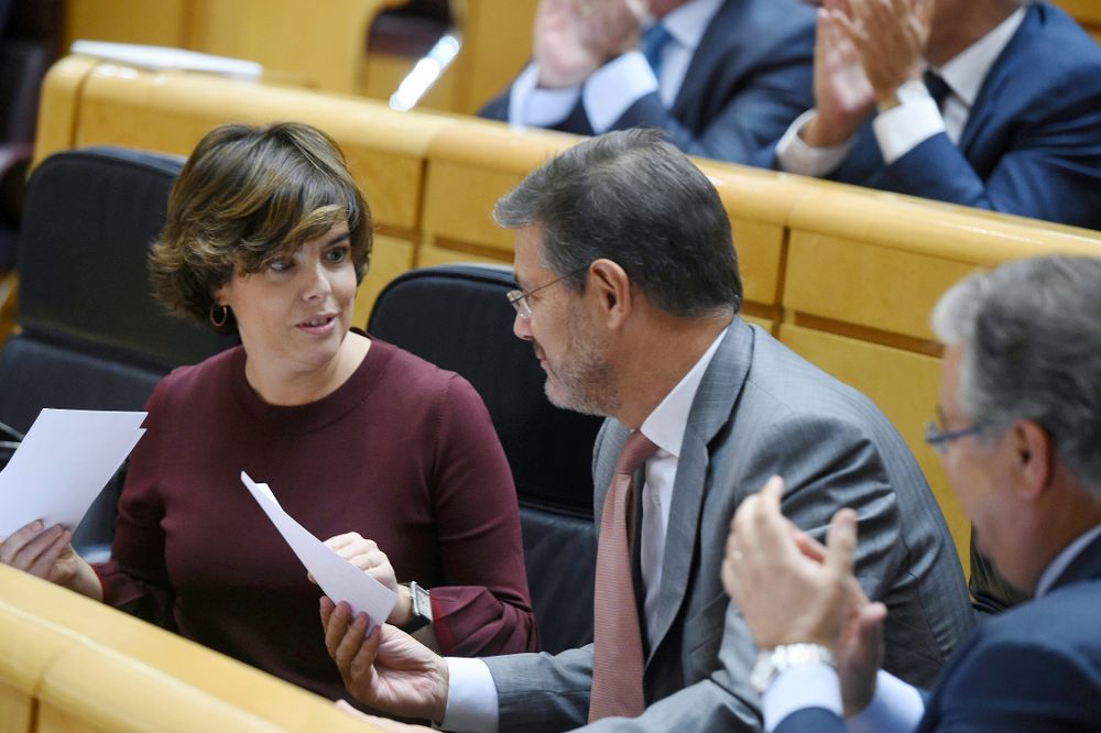 La vicepresidenta del gobierno Soraya Sáez de Santamaría y el ministro de Justicia Rafael Catalá conversan durante el pleno celebrado esta tarde en el Senado.