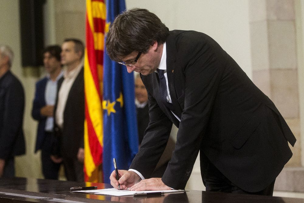 El presidente de la Generalitat, Carles Puigdemont, firma el documento sobre la Independencia después de comparecer ante el pleno del Parlament.