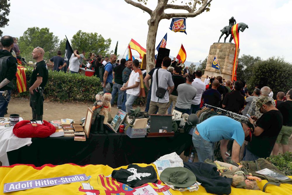 Ambiente y tenderetes con productos que aluden a Adolf Hitler en la plaza de Sant Jordi, en la manifestación convocada por la extrema derecha.