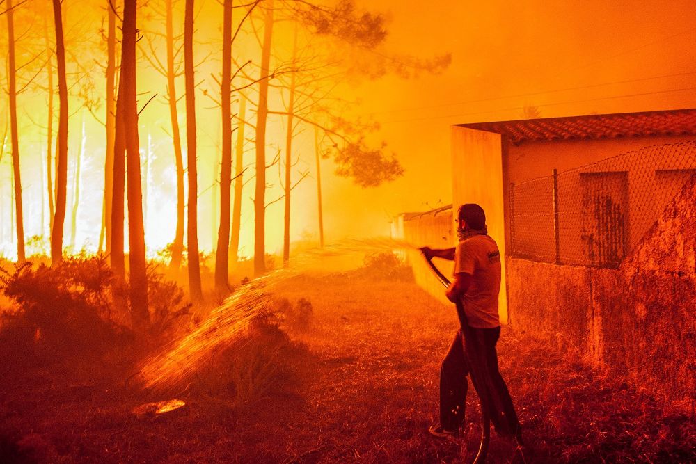Un hombre lucha contra las llamas en un incendio forestal declarado en Adica, Tondela (Portugal).