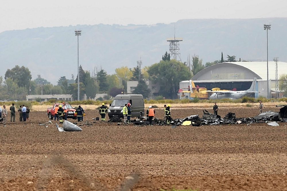 El piloto del F-18 siniestrado cuando despegaba de la base aérea de Torrejón de Ardoz (Madrid) ha fallecido en el accidente.En la foto, equipos de emergencia entre los restos del aparato siniestrado..