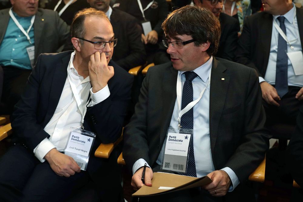 El presidente de la Generalitat, Carles Puigdemont (i), junto al conseller de la Presidencia Jordi Turull (i), al inicio de la reunión extraordinaria del consell nacional del PDeCAT.