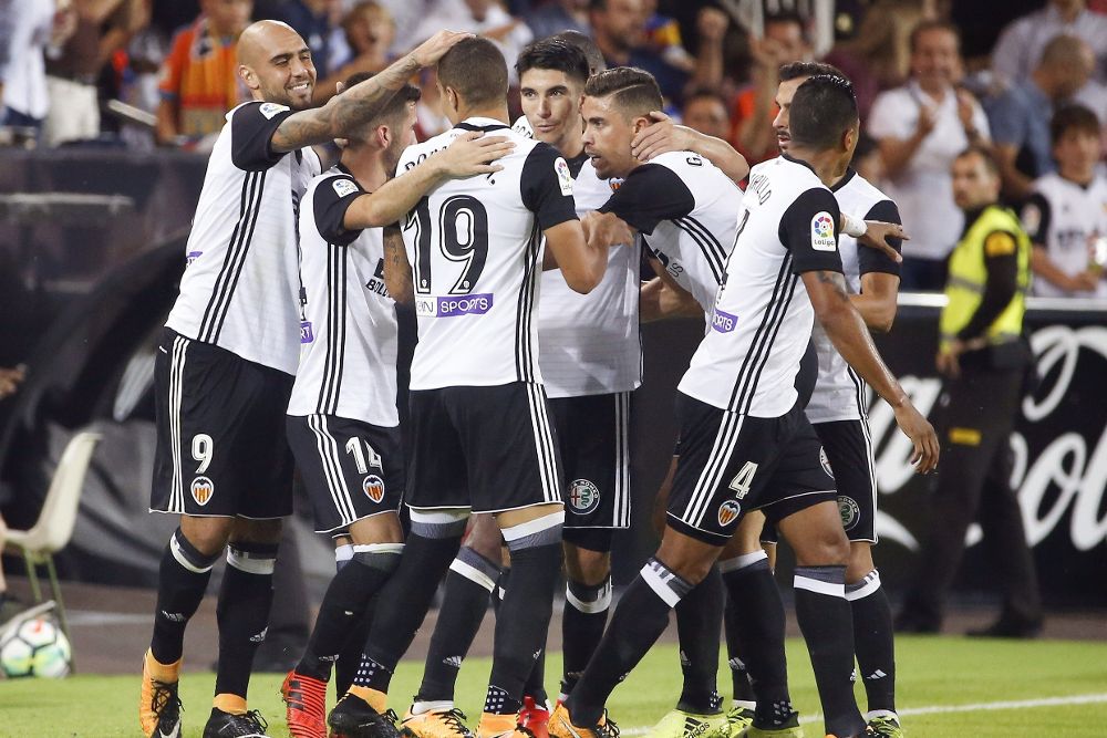 El delantero italiano del Valencia CF Simone Zaza (i) celebra su gol, segundo del equipo ante el Sevilla FC, con sus compañeros, durante el partido de la novena jornada de Liga en Primera División que se disputa esta tarde en el estadio de Mestalla, en Valencia.