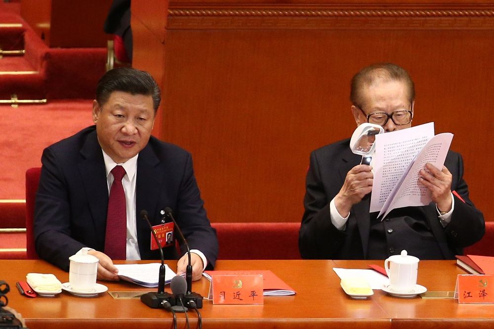 El expresidente chino Jiang Zemin inspecciona unos documentos junto al actual presidente chino y secretario general del Partido Comunista de China, Xi Jinping (i), durante la ceremonia de clausura del XIX Congreso Nacional del Partido Comunista de China.