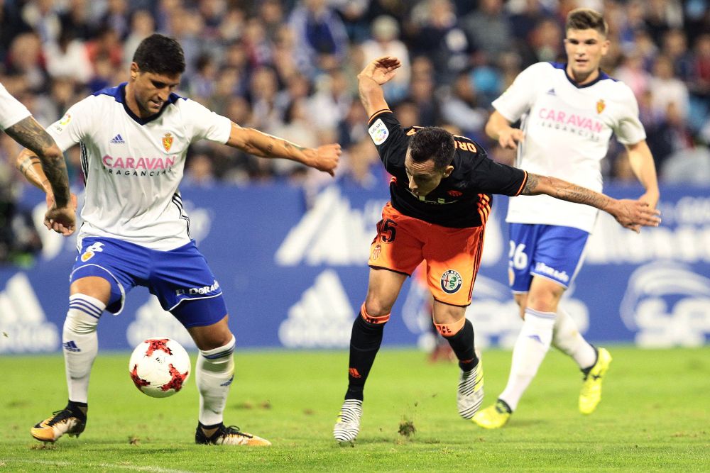 El jugador del Real Zaragoza Grippo (i) lucha el balón con orellana, del Valencia CF.