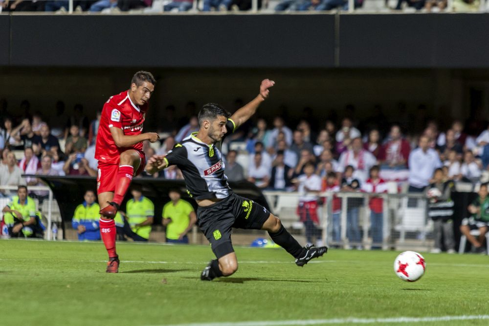 El delantero francés del Sevilla FC Wissam Ben Yedder (i) lanza a puerta ante un jugador del Cartagena.