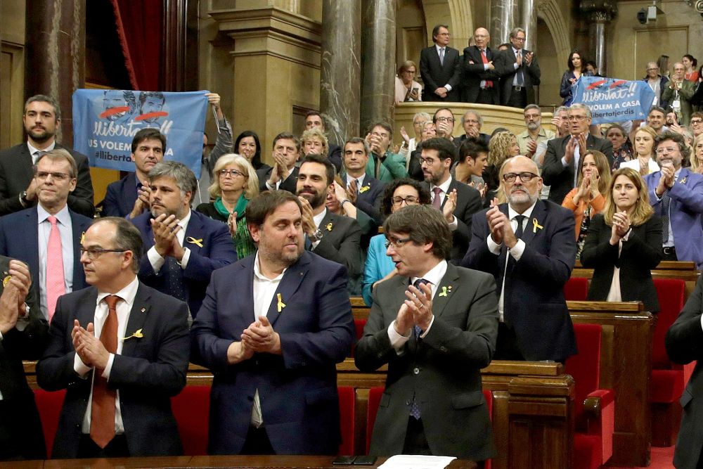 El presidente de la Generaliatat, Carles Puigdemont (d) y el vicepresidente del Govern y conseller de Economía, Oriol Junqueras (2d), junto a los diputados de JxSí y la CUP y sin los diputados del PSC, PPC y Ciudadanos, aplauden tras aprobarse en el pleno del Parlament, la declaración de independencia, con los votos de Junts pel Sí (JxSí) y la CUP, una resolución en la que, en su preámbulo, se declara un "Estado independiente en forma de república", y una segunda resolución que plantea abrir un "proceso constituyente" para redactar la Constitución del nuevo Estado.