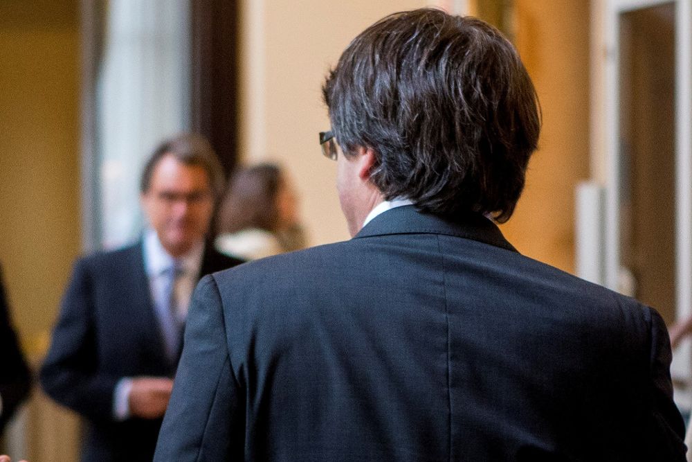 El ya expresidente de la Generalitat, Carles Puigdemont, con su compañero Artur Mas (i) en los pasillos del Parlament.