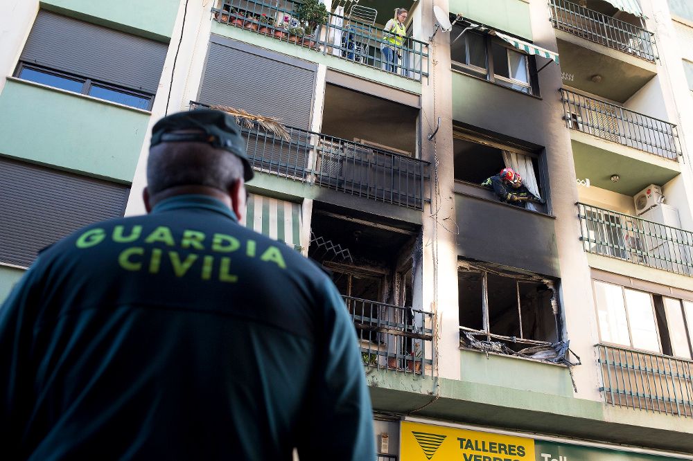 Un agente de la Guardia Civil observa la vivienda de un edificio de cuatro alturas ubicado en el municipio de Burriana (Castellón) en el que esta mañana se ha declarado el incendio.