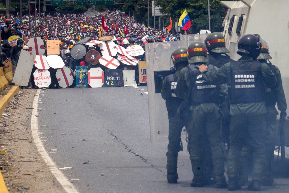 Fotografía de archivo fechada el 3 de mayo de 2017, que muestra a un grupo de manifestantes mientras se enfrentan a agentes de la Guardia Nacional Bolivariana en Caracas.