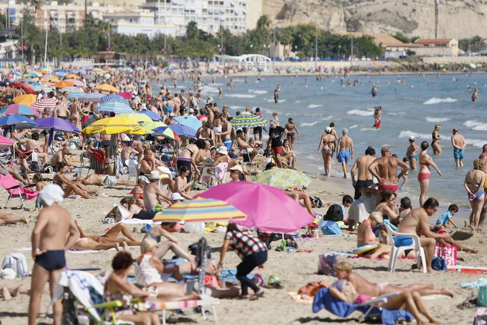 Miles de turistas disfrutan del sol, las playas y las altas temperaturas reinantes en el Levante español, como en la playa del Postiguet de Alicante.