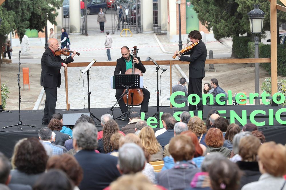 Un trío de cuerda interpreta música clásica bajo el título "Concierto del silencio", en un escenario ubicado frente a la capilla del cementerio de la Almudena, en Madrid.