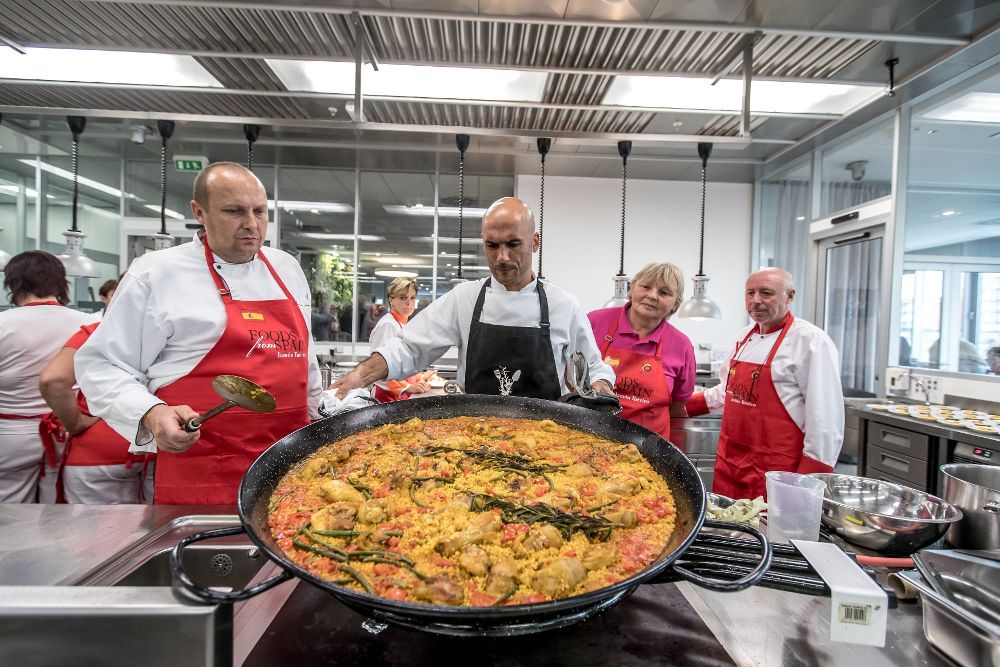 El chef español Enrique García enseña a cocineros de comedores escolares cómo cocinar paella durante un taller en Praga.