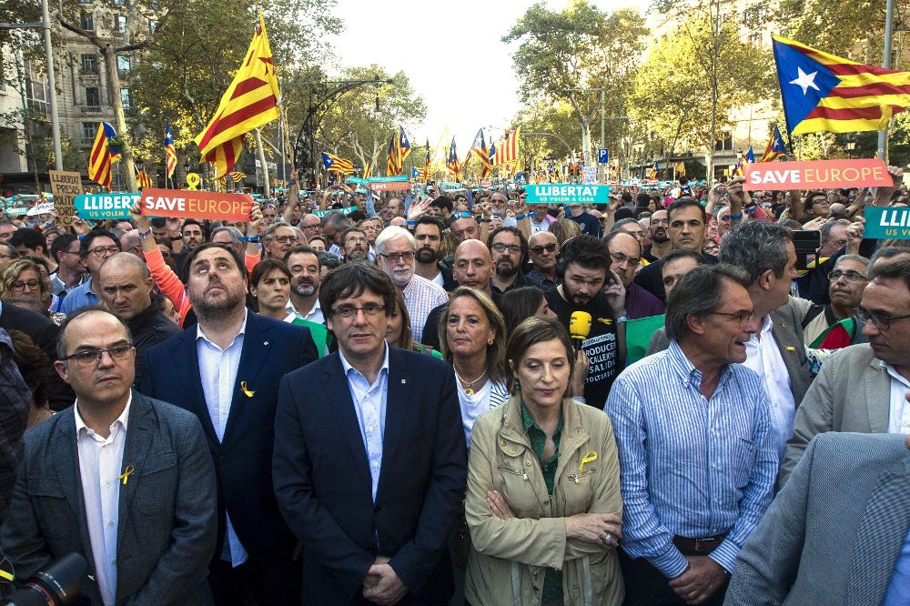 El presidente de la Generalitat, Carles Puigdemont (2i), en la manifestación convocada por la Mesa por la Democracia para pedir la libertad de Jordi Sànchez y Jordi Cuixart, después que el Gobierno haya anunciado que propondrá al Senado su destitución y la de todos los consellers.