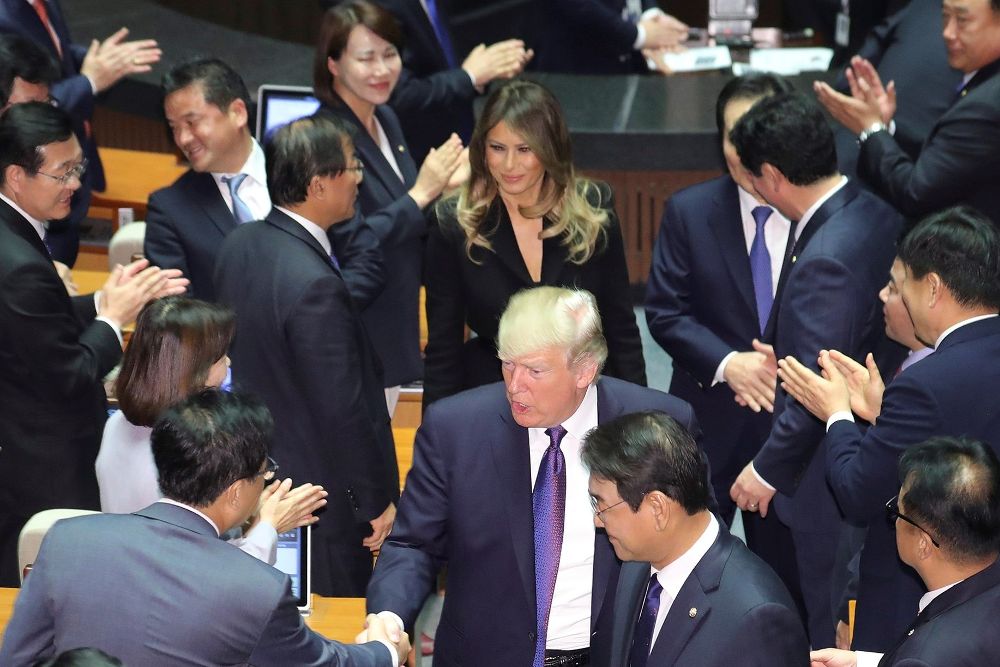El presidente de los Estados Unidos, Donald Trump (c), saluda a diputados junto a su esposa, Melania Trump, tras su discurso en la Asamblea Nacional en Seúl (Corea del Sur) hoy, 8 de noviembre de 2017.