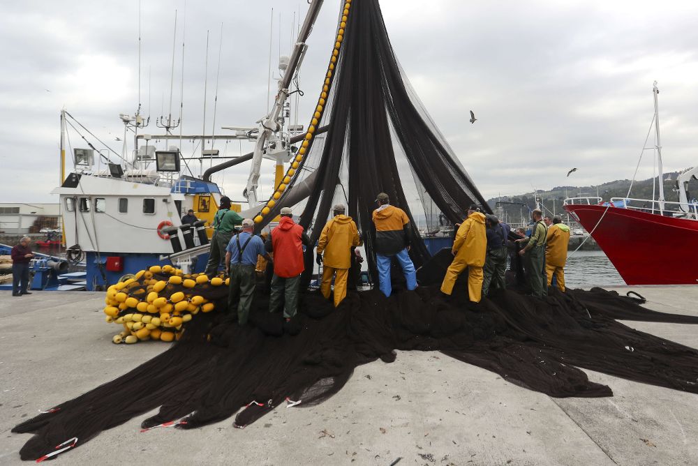 La tripulación de un barco pesquero de bajura limpia las redes.